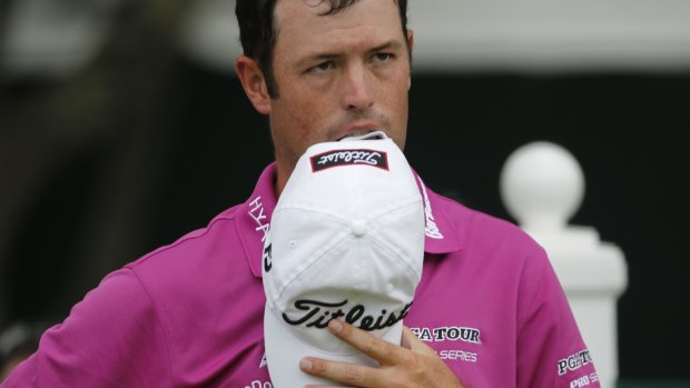 Robert Streb takes a bite out of his hat as he waits to hit on the 18th tee.