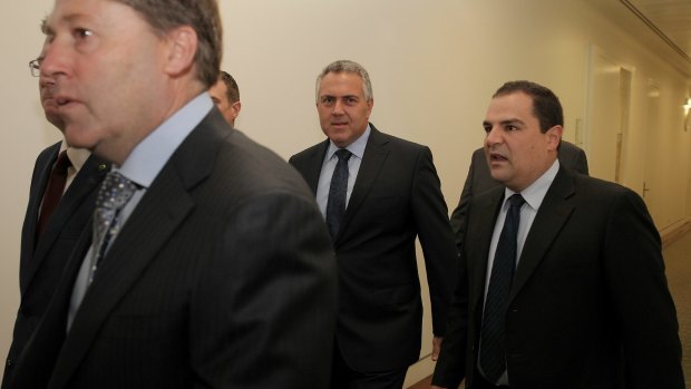 Treasurer Joe Hockey at the back of a big group accompanying Prime Minister Tony Abbott as he arrives for the party room meeting at Parliament House on Monday.