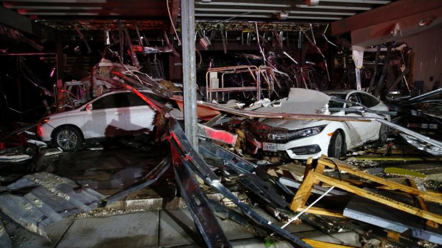 Cars and trucks were damaged when the walls of a Dodge dealership were blown by a tornado in Canton, Texas.