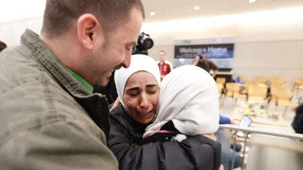 Hisham, left, and Mariam Yasin, centre, welcome their mother Najah al-Shamieh, from Syria, after immigration authorities released her at Dallas-Fort Worth Airport on Saturday.