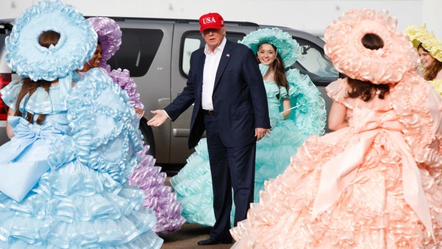 President-elect Donald Trump is greeted by the Azalea Trail Maids after arriving at the airport for a rally in Alabama.