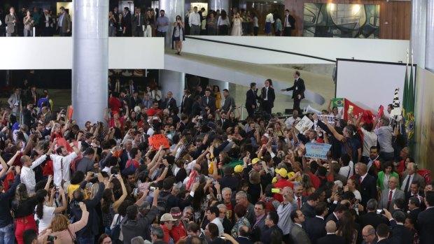 Supporters of Brazilian President Dilma Rousseff fill the lobby of Planalto presidential palace on Monday after a ceremony where she launched new federal universities in Brasilia.