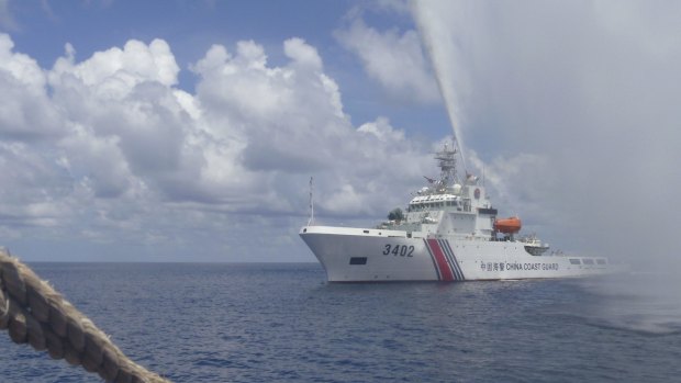 A Chinese Coast Guard boat sprays a water cannon at Filipino fishermen near Scarborough Shoal in the South China Sea.