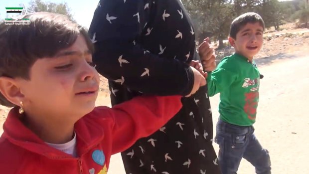 A grab from a video shows two children being pulled to safety after air strikes in Aleppo.