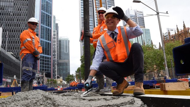 Andrew Constance (right) witnessing the first track being cemented in place.