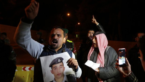A relative of Islamic State captive Jordanian pilot Lieutenant Moaz Kasasbeh holds his picture, demanding the Jordanian government negotiate for his release. 