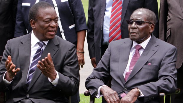 Emmerson Mnangagwa, left, then Vice President of Zimbabwe chats with Robert Mugabe in 2014.