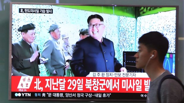 A man passes by a TV news program showing a file image of North Korean leader Kim Jong-un on Sunday.