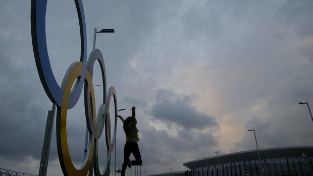 Monalisa Paduin poses for photos in front of the Olympic rings  at Olympic Park in Rio. Two car accidents have taken place on the road that access the park in the last few days.
