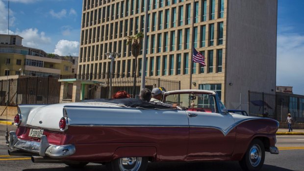 Tourists ride a classic convertible car on the Malecon beside the US embassy in Havana, Cuba, on Tuesday.