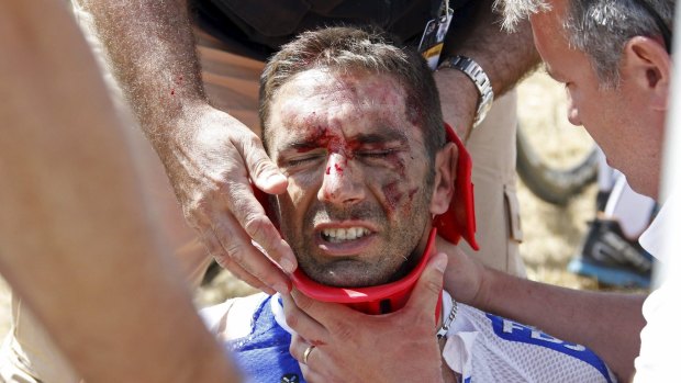 FDJ rider William Bonnet of France receives medical help as he sits on the ground after falling.