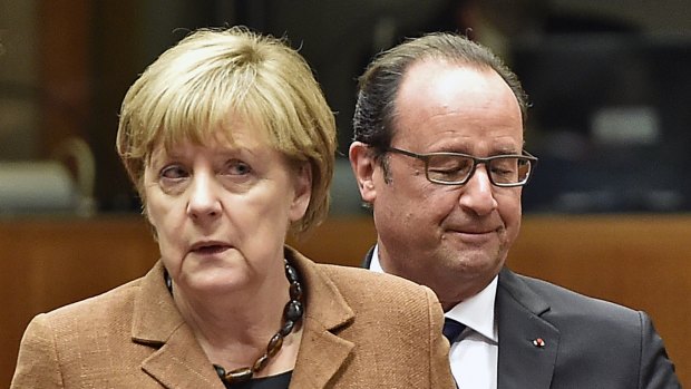 German Chancellor Angela Merkel, left, and French President Francois Hollande  arrive  at the emergency EU heads of state summit on the migrant crisis at the EU Commission headquarters in Brussels on Wednesday.