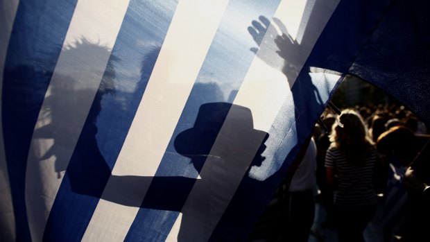 The shadow of a protester is seen on a Greek national flag during a pro European Union  demonstration in Athens on Monday. 