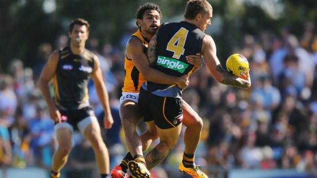 You're going nowhere... Hawthorn's Cyril Rioli gets a firm grip on Dustin Martin of the Tigers.