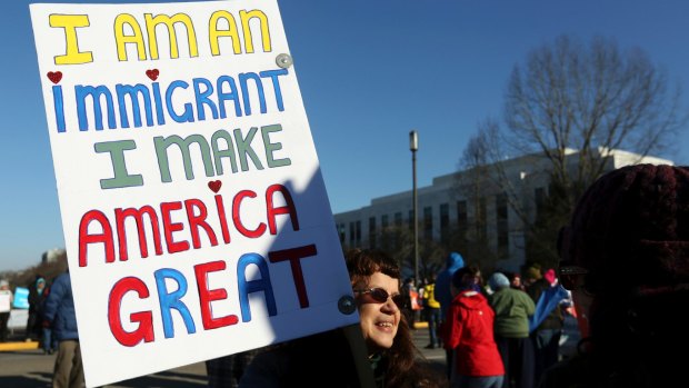 Ellen Furstner, 62, of Marcola, carries a sign during an immigrant rights rally at the Oregon State Capitol in Salem.