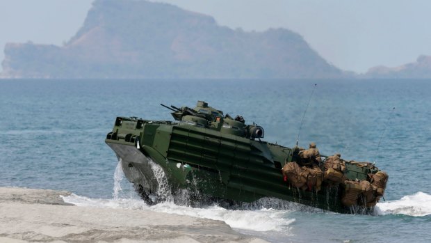 A US Navy amphibious assault vehicle with Philippine and US troops on board storms the beach at a combined assault exercise opposite one of the disputed South China Sea islets.