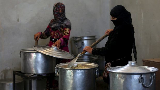Syrian displaced women prepare food for refugees in the camp in Ain Issa, northern Syria.