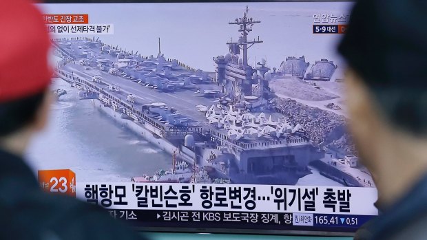 People in Seoul, South Korea, watch a TV news program showing the aircraft carrier USS Carl Vinson on Wednesday.