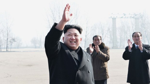 North Korean leader Kim Jong-un waving during a photo session with the builders of the Construction Bureau 8 in Pyongyang.  