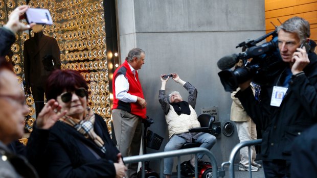 Pedestrians stop to take pictures or just look at Trump Tower in New York.