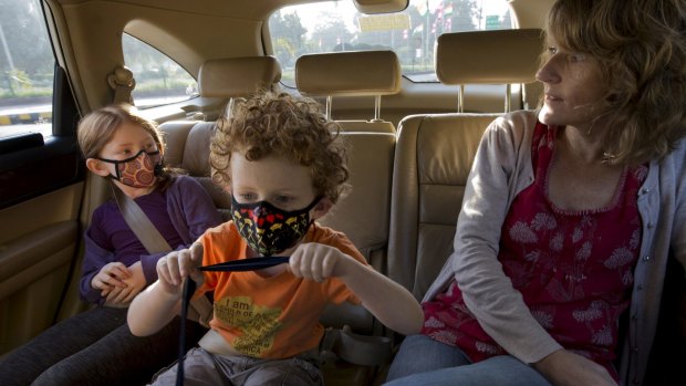 US expatriates Hannah and Alex Dawes wear masks en route to the American Embassy School in New Delhi in recent days. 
