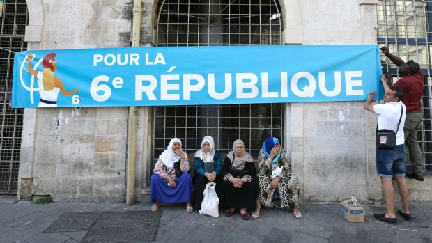 Supporters of far-left candidate Jean-Luc Melenchon put up a banner for the legislative elections in the southern city of Marseille. 