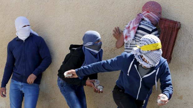 Palestinian youths throw stones towards Israeli police during clashes in the Israeli-occupied East Jerusalem neighbourhood of al-Tur after Ali Abu Ghannam's death.