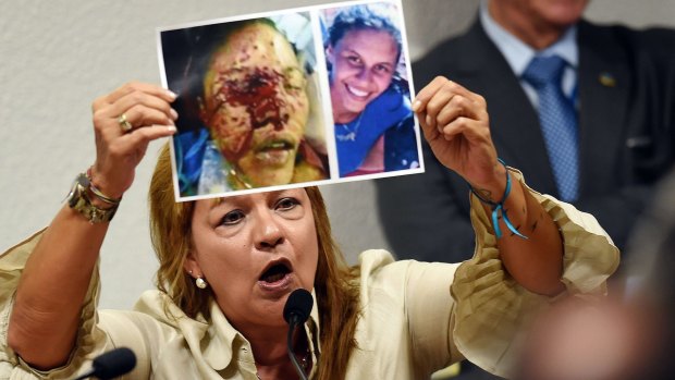 Vera Orozco shows pictures of her daughter Geraldine, killed by members of the Venezuelan National Guard, at a public hearing in Brasilia on Thursday. Geraldine Moreno died in February 2014 after receiving shots during protests against the government of Nicolas Maduro. 