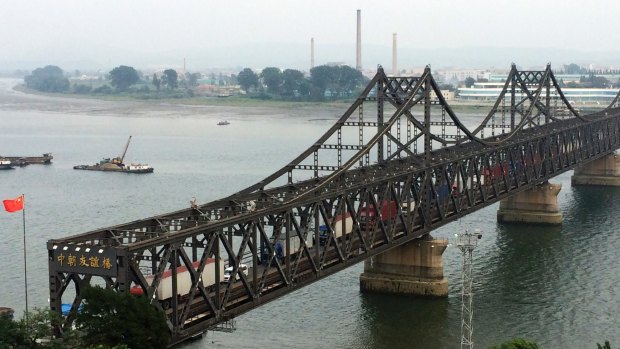 Tucks cross the friendship bridge connecting Dandong in China and Sinuiju in North Korea.