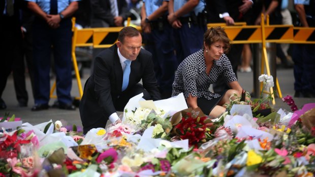 Prime Minister Tony Abbott and wife Margie lay a bouquet of flowers outside the Lindt cafe.