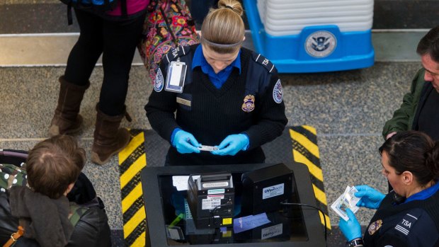 Transportation Security Administration (TSA) officers check passenger's identification at a security checkpoint at Ronald Reagan National Airport in Washington.