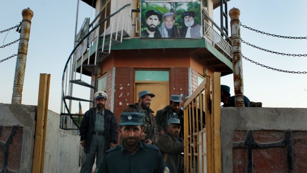 Afghan police in Oruzgan beneath portraits of the late Matiullah Khan and former president Hamid Karzai. Both men were prominent figures in the Popalzai tribe, a minority in the province which aligned itself with foreign forces.