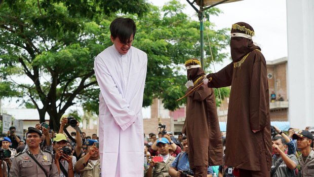 The masked men took turns to deliver the lashes  - 83 in the end - with a cane according to Aceh's sharia-inspired laws.