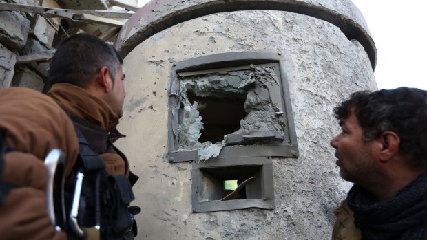 Afghan security personnel inspect the damage to the Spanish Embassy in Kabul on Saturday. 