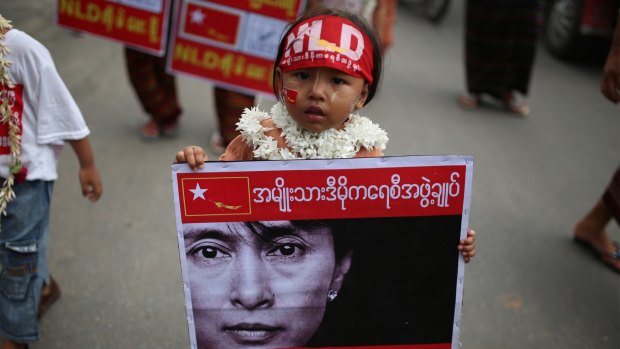 A child holds a sign with the face of Myanmar's opposition leader Aung San Suu Kyi that reads "We stand by Daw Suu" in Mandalay last month.