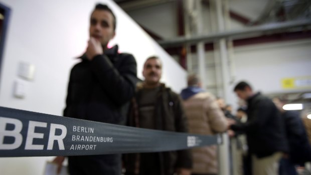Men leaving Germany queue up in front of a federal police office at the Tegel airport in Berlin.