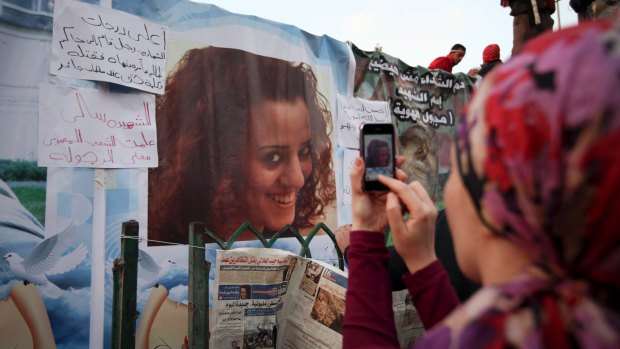An anti-government protester takes a picture of a poster of Sally Zahran who was killed in during clashes in Tahrir Square in 2011.