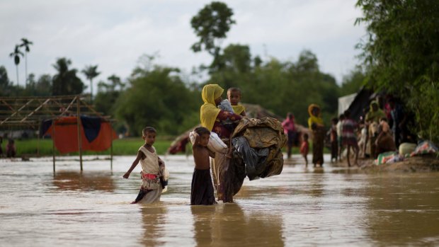 A Rohingya Muslim family walk with their belongings to find another shelter after their Bangladesh camp was inundated.
