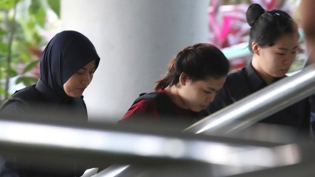 Indonesian Siti Aisyah, centre, is escorted by police as she arrives in court in Kuala Lumpur.