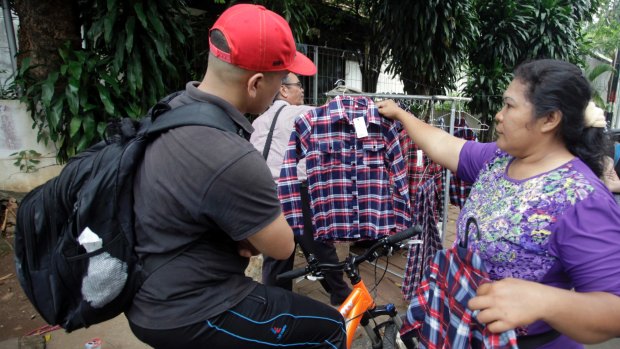 Santi Panggabean, right, does a brisk trade in Ahok's trademark plaid shirt. But the governor's popularity is not reflected in election polling.