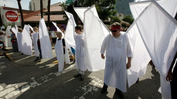 Counter-demonstrators dressed as angels block the view of extremist Christian protesters near the funeral service for Christopher Andrew Leinonen in Orlando.