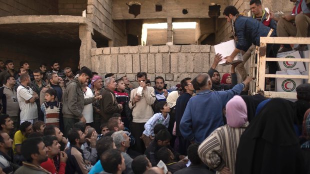 Residents gather to receive food supplies being distributed in an area previously held by IS militants and now controlled by Iraqi forces in Mosul on Thursday.