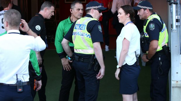 Aftermath: Police speak to Adelaide United staff in the tunnel after the match between the Reds and the Roar.