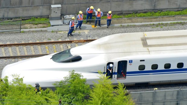Police officers investigate a Shinkansen bullet train after it made an emergency stop in Odawara, south of Tokyo.