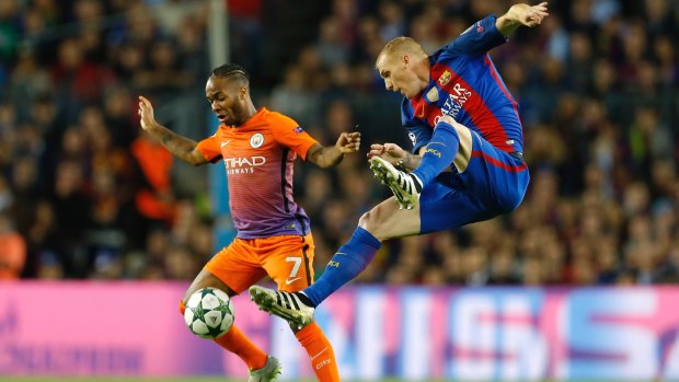 City's Raheem Sterling, left, fights for the ball with Barcelona's Jeremy Mathieu.