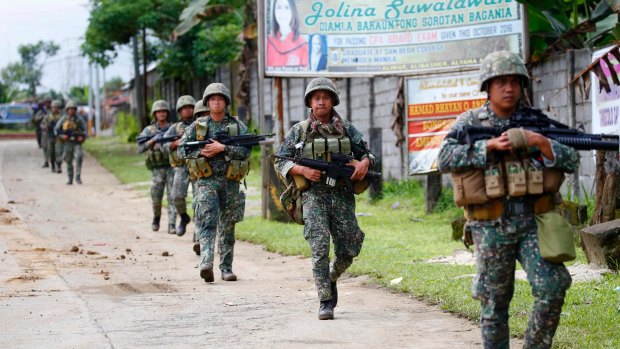 Philippine marines walk to the frontline in Marawi  in May. Fighting continues in the southern city.