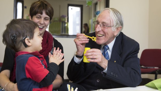 Graeme Clark who invented bionic ear with 2yr-old Declan Zemora who has just got his hearing.
