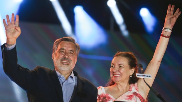 Presidential candidate Alejandro Guillier and his wife Cristina Farga wave to supporters during their closing campaign rally.