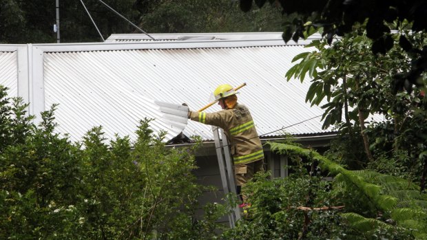 A fireman checks the roof of Kathy Jackson's house. 