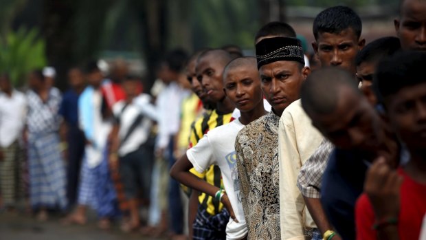 Rohingya migrants who arrived in Indonesia last week by boat wait in line for breakfast at a temporary shelter in Aceh Timur.